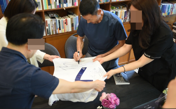 '나는 읽고 쓰고 버린다' 책 저서 손웅정 감독이 팬에게 사인한뒤 기념촬영을 하고 있다. 전우용 기자