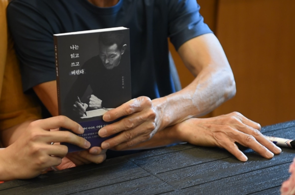 '나는 읽고 쓰고 버린다' 책 저서 손웅정 감독이 팬에게 사인한뒤 기념촬영을 하고 있다. 전우용 기자