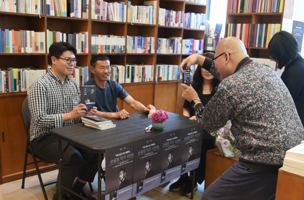 '나는 읽고 쓰고 버린다' 책 저서 손웅정 감독이 팬에게 사인한뒤 기념촬영을 하고 있다. 전우용 기자