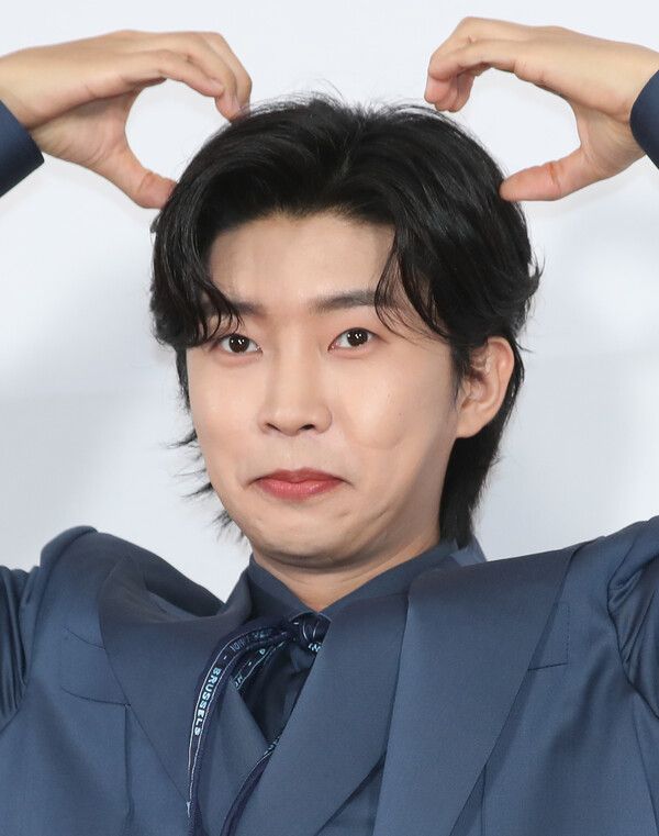 임영웅이 손하트 모양을 한 채 머리 위로 두 팔을 들어올린 모습