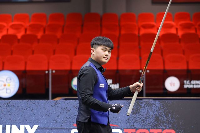 챔피언십포인트를 득점한 오명규가 큐를 들고 주먹을 불끈 쥐고 있다.