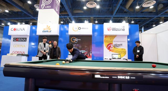 PBA 전시관에서 프로당구 당구용품을 체험하고 있는 관람객.