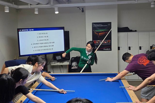 학생들에게 당구 원포인트 레슨을 하고 있는 김진아.