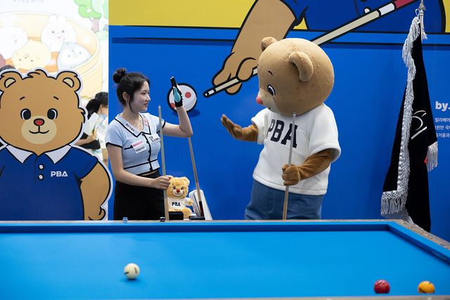 '캐릭터 라이센싱 페어 2025'에 참가한 PBA 공식 캐릭터 '빌리베어'가 LPBA 한지은(에스와이)과 하이파이브 하고 있다.