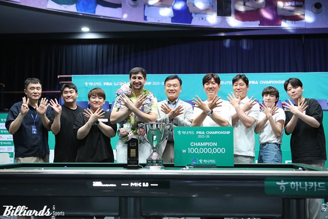 마르티네스의 우승을 축하하는 크라운해태 기종표 단장(가운데)과 소속 선수들.