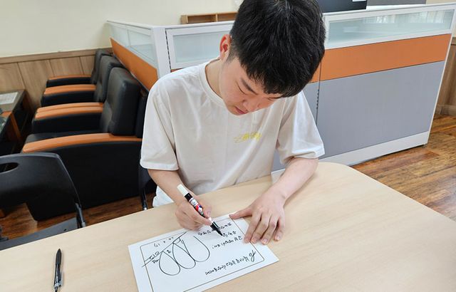 김영원이 17일 모교 북서울중학교에서 기탁식을 가진 후 기념 사인을 하고 있다.