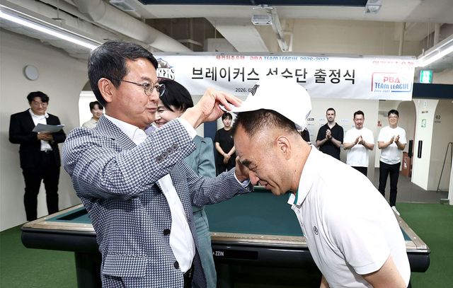 김영진 단장(왼쪽)이 2일 서울 강남구 논현 PBA 라운지에서 열린 '브레이커스 선수단 출정식'에서 브레이커스 소속 리더 이승진에게 모자를 씌우고 있다.