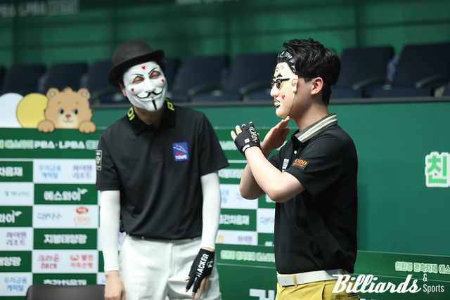 가면을 쓰고 세리머니를 하고 있는 김영원과 그런 김영원의 모습을 흐뭇하게 지켜보고 있는 해커.