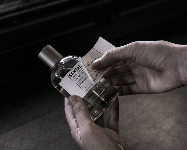 리필한 향수 보틀에 새 라벨지를 덧붙이는 모습