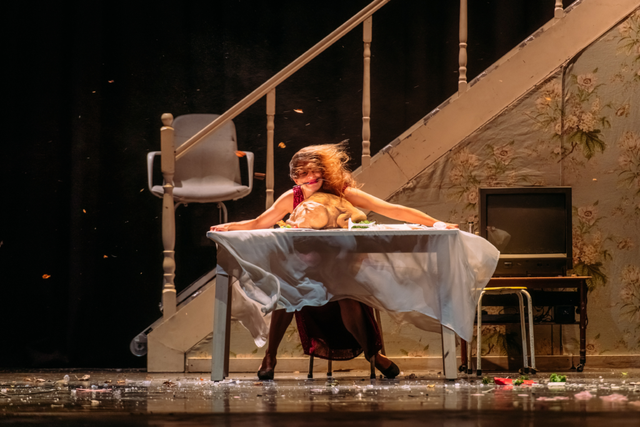 거센 바람이 불어오는데도 식탁에 앉아 커다란 칠면조 구이를 먹으려는 여성