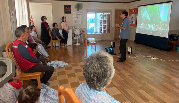 경남 김해시 주촌면 한 경로당에서 자원봉사자 권영수씨가 마을 어르신들에게 영화 상영에 앞서 '경로당 영화관'에 대한 설명을 하고 있다. (사진=김해시)