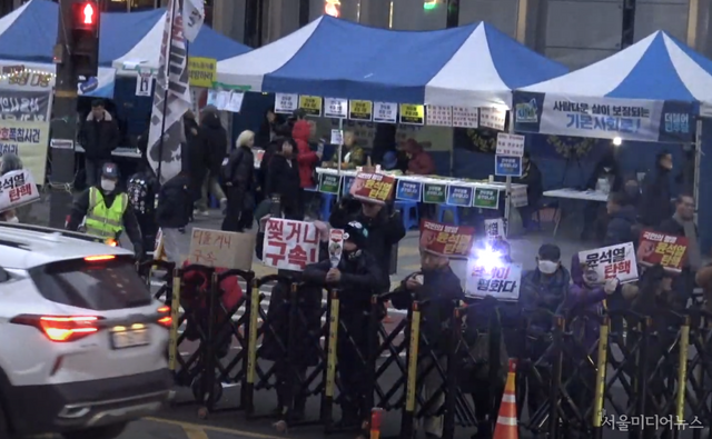 촛불단체측의 집회 장소에 '기본사회' 현수막이 눈길을 끈다. 피켓에는 '찢거니 구속'이라는 정체불명의 문구도 등장했다. (사진=서울미디어뉴스)