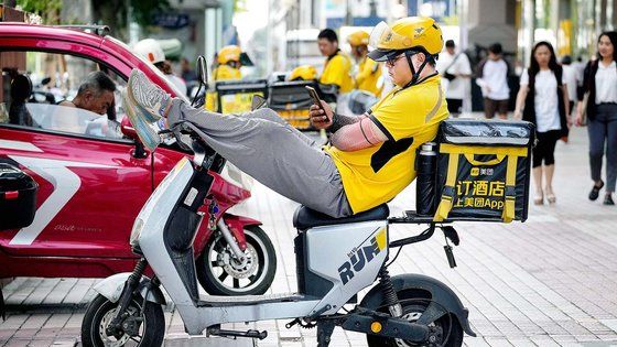 중국 베이징의 한 쇼핑몰에서 젊은 배달기사가 오토바이에서 휴식을 취하고 있다. ⓒAP 연합뉴스