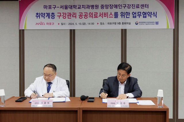 박강수 마포구청장이 서광석 서울대 중앙장애인구강진료센터장과 업무 협약서에 서명을 하고 있다 ⓒ마포구청