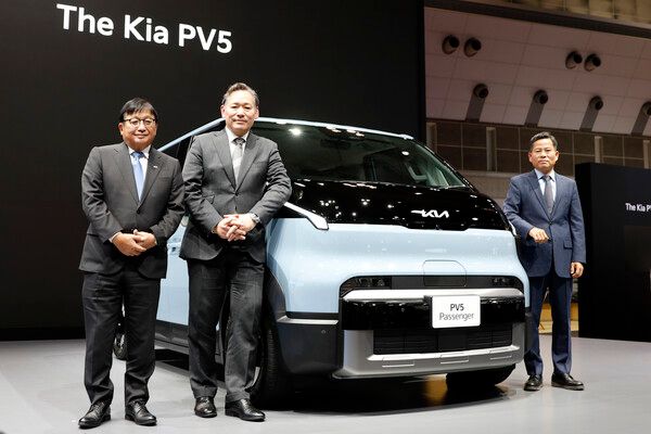 2025 일본 모빌리티쇼에서 기아 EV5 패신저 모델과 함께 포즈를 취한 소지츠의 후지모토 마사요시 회장, 기아 PBV 제팬 타지마 야스나리 대표이사, 기아 PBV 비즈니스사업부 김상대 부사장(왼쪽부터). 사진=전현철 기자.