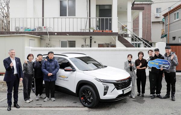쉐보레 트랙스 크로스오버 앞에서 기념 사진을 촬영하고 있는 GM 한국사업장 임직원들과 인천 해늘단기보호센터 거주자 및 관계자들. 사진=지엠한마음재단