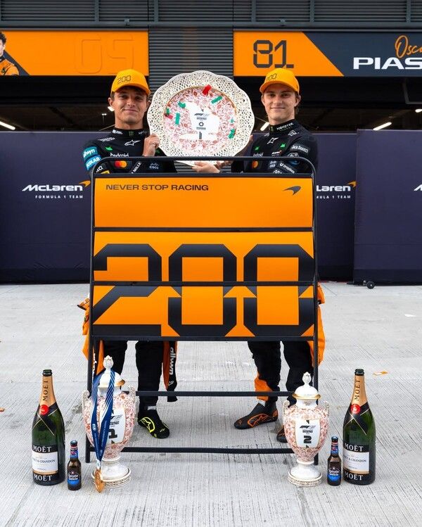 맥라렌의 F1 통산 200번째 우승을 축하하는 사인보드와 컨스트럭터즈 우승 트로피를 함께 든 우승자 랜도 노리스(왼쪽)과 2위 오스카 피아스트리. 사진=맥라렌.