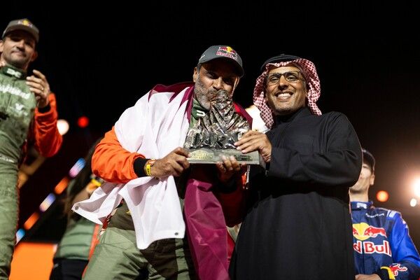 2026 다카르 랠리 시상식에서 트로피에 입맞추는 우승자 나세르 알 아티야(왼쪽). 사진=다카르 랠리.