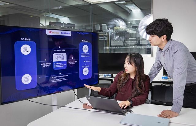 SK텔레콤과 삼성전자 연구원이 AI 기반 5G 기지국 품질 최적화 기술 실증에 대해 논의하는 모습. (사진=SK텔레콤)