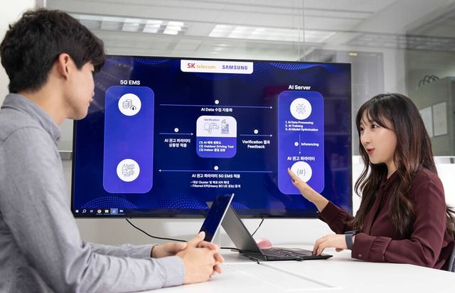 SK텔레콤과 삼성전자 연구원이 AI 기반 5G 기지국 품질 최적화 기술 실증에 대해 논의하는 모습. (사진=SK텔레콤)