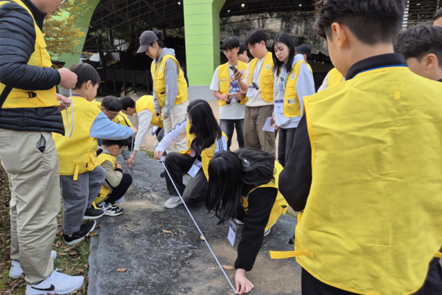전문가와 함께 공룡 발자국 크기를 측정하는 참가자들. (사진=국립광주과학관)