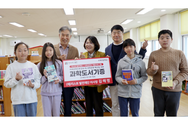 지스트발전재단과 GIST 사회공헌단 ‘피움(PIUM)’이 담양 수북초등학교에서 과학도서 전달식을 개최하고 어린이들과 함께 기념촬영을 하고 있다. (왼쪽부터) (재)지스트발전재단 김해명 이사장, 수북초등학교 김진홍 교장, (재)지스트발전재단 이근신 이사. (사진=지스트)