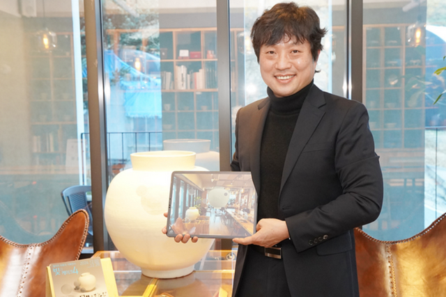 서영호 아이씨에프 대표가 변승훈 작가의 작품을 자사 AR 애플리케이션 ‘에이알쿠키’로 보여주고 있다. (사진=아이씨에프)