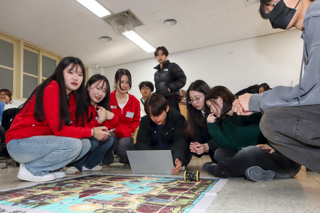 영흥중학교 3학년 학생들이 ‘KT 대학생 IT 서포터즈’ 구성원들에게 AI 코딩 강의를 들으며 실습을 하고 있다. (사진=KT)