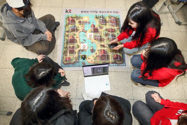 영흥중학교 3학년 학생들이 ‘KT 대학생 IT 서포터즈’ 구성원들에게 AI 코딩 강의를 들으며 실습을 하고 있다. (사진=KT)