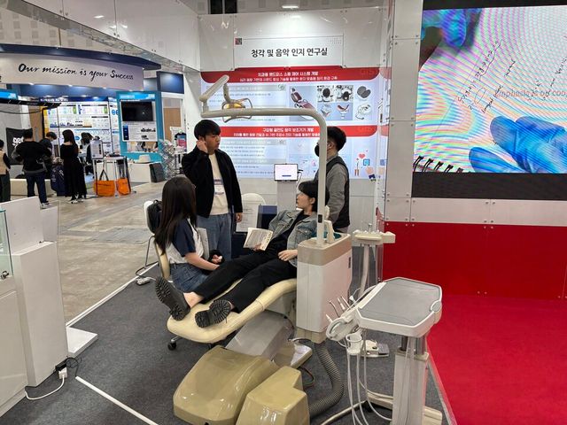 ‘청각 및 음악 인지 연구실(송은성 교수)’에서 만든 ‘치과용 핸드피스의 소음제어 시스템’ 전시 부스를 찾은 관람객이 체험하고 있다. (사진=지스트)