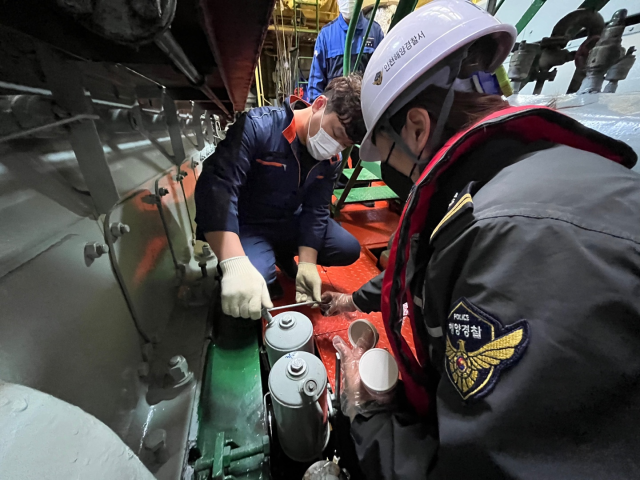 해양경찰이 선박에서 황함유량을 점검하기 위해 시료를 채취하고 있다. 해양경찰청제공