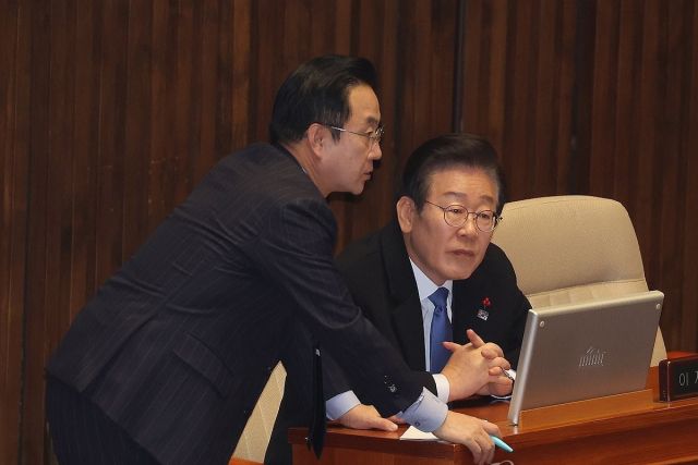 더불어민주당 이재명 대표가 13일 오후 국회에서 열린 본회의에 참석해 박성준 원내수석부대표와 대화하고 있다. 연합뉴스