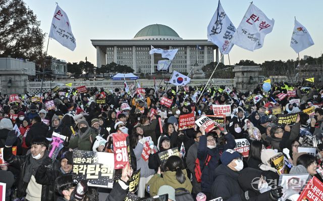 윤석열 대통령 탄핵소추안이 찬성 204명·반대 85명로 통과된 14일 국회 앞에서 '윤석열 즉각 퇴진·사회대개혁 비상행동' 주최로 열린 촛불집회에서 참가한 진보단체와 시민들이 탄핵소추안이 통과되자 환호하고 있다. 홍기웅기자