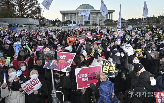윤석열 대통령 탄핵소추안이 찬성 204명·반대 85명로 통과된 14일 국회 앞에서 '윤석열 즉각 퇴진·사회대개혁 비상행동' 주최로 열린 촛불집회에서 참가한 진보단체와 시민들이 탄핵소추안이 통과되자 환호하고 있다. 홍기웅기자