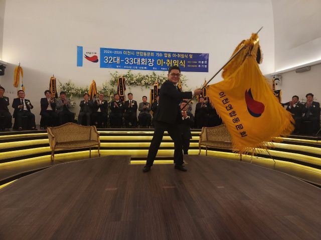 이천시연합동문회 제33대 유기철 회장이 취임식에서 동문회 기를 힘차게 흔들고 있다. 김정오 기자.