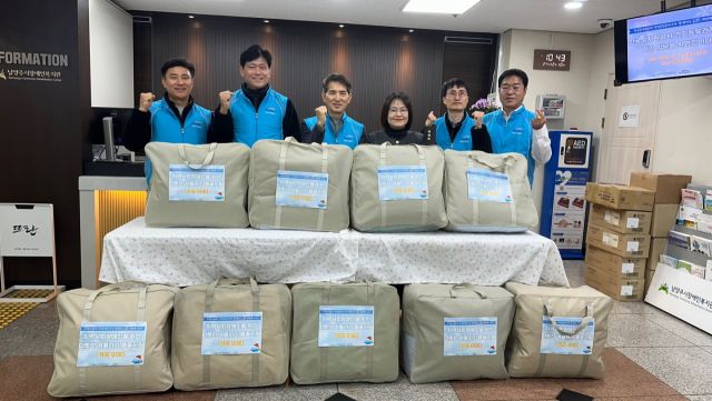 지난 10일 남양주시장애인복지관에서 한국수자원공사 경기동북권지사 직원들이 시장애인복지관에 이불을 전달하며 김소영 관장과 함께 기념사진을 촬영하고 있다. 남양주시 제공