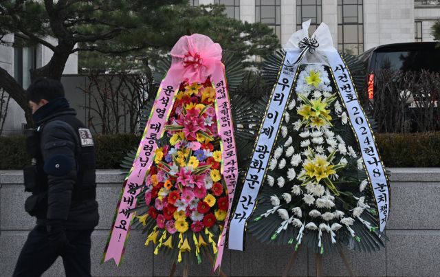 15일 헌법재판소 앞에 윤석열 대통령 탄핵심판 사건번호인 '2024헌나8'가 적힌 근조 화환과 윤 대통령을 응원하는 화환이 나란히 놓여 있다.조주현기자