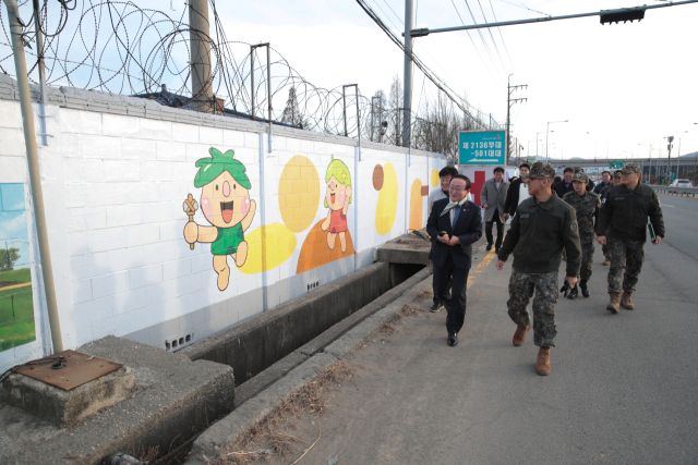 지난 13일 연천군 전곡읍 은대리 5사단 의무대에서 열린 간담회에서 김덕현 연천군수 등을 비롯한 민·관·군 관계자들이 완성된 벽화를 바라보며 대화를 나누고 있다. 연천군 제공