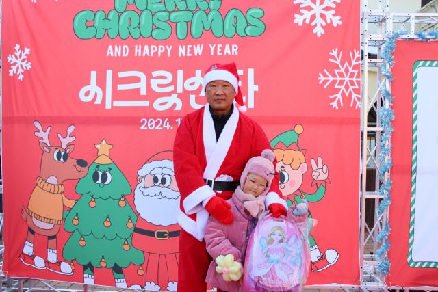 최근 한국민속촌에서 열린 용인시기흥장애인복지관 크리스마스 행사 ‘제5회 시크릿산타’에 참여한 자원봉사자 일일 산타와 선물을 받은 아동이 기념촬영을 하고 있다. 용인시기흥장애인복지관 제공