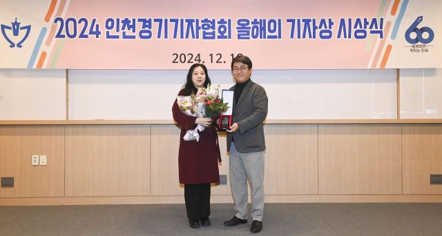 경기일보 정치부 김경희 차장이 18일 경인일보 경기본사에서 열린 인천경기기자협회 2024 올해의 기자상 시상식에서 수상한 뒤 황성규 협회장과 기념촬영을 하고 있다. 인천경기기자협회 제공