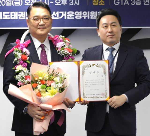 김평(왼쪽) 경기도태권도협회장 당선인이 당선증을 받고 기념촬영을 하고 있다.경기도태권도협회 제공