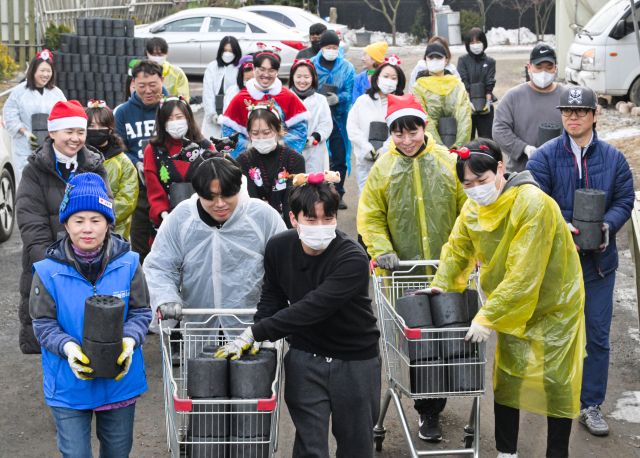 연탄한장 봉사단원들이 산타모자와 루돌프 머리띠 등 이색복장으로 연탄 나눔 봉사활동을 하고 있다.조주현기자