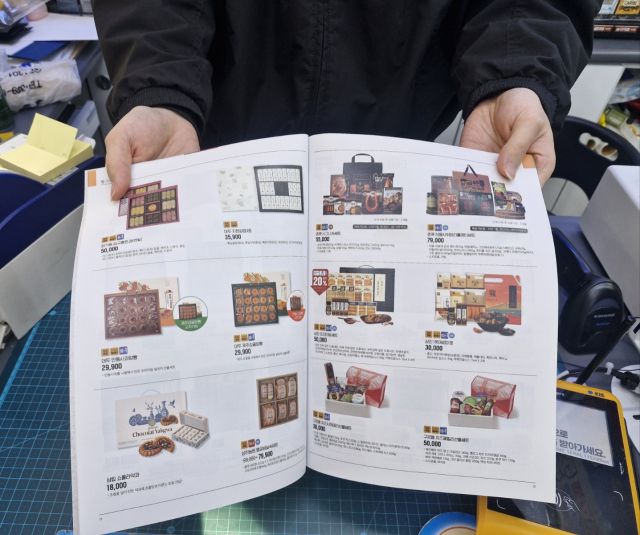 군포시에 위치한 이마트24 한 매장에서 직원이 설 선물세트 카탈로그를 내보이고 있다. 김미지 인턴기자