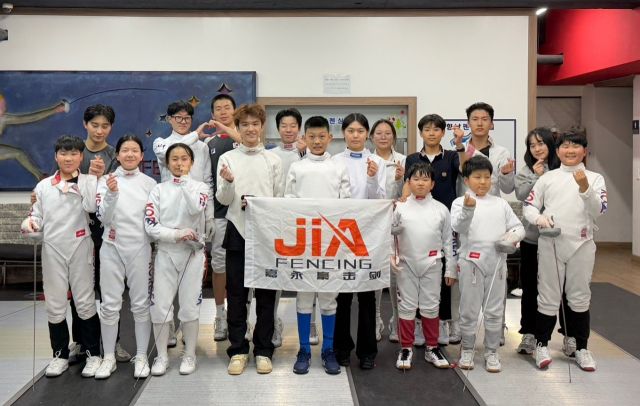 일주일 일정으로 화성시를 찾은 중국 광저우의 자융하오 펜싱클럽 선수 3명(가운데)이 K1 펜싱클럽 선수들과 훈련에 앞서 기념촬영을 하고 있다.K1펜싱클럽 제공