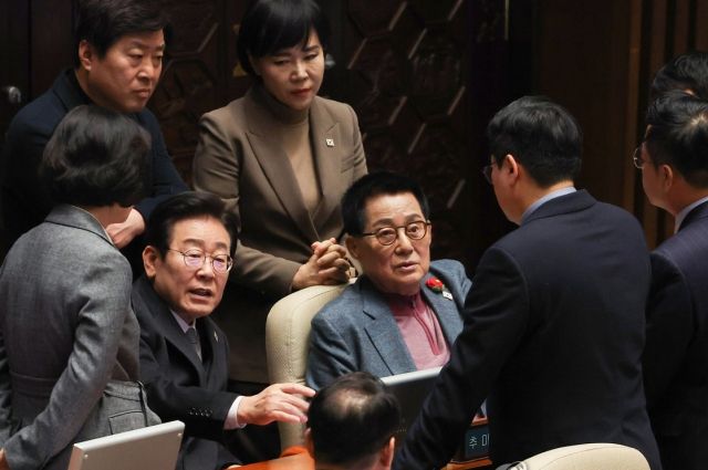 더불어민주당 이재명 대표가 26일 오후 국회 본회의에서 박지원, 전현희 의원 등과 대화하고 있다. 연합뉴스