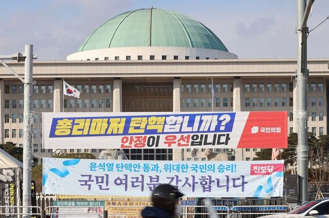 25일 서울 여의도 국회의사당 정문에 걸린 “총리마저 탄핵합니까, 안정이 우선입니다”라는 국민의힘 현수막. 연합뉴스