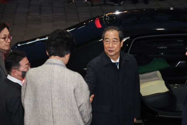 한덕수 국무총리가 27일 오후 국회의 탄핵소추 의결 뒤 서울 종로구 정부서울청사를 떠나며 직원들과 인사하고 있다. 연합뉴스