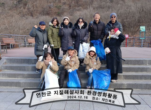 연천군 지질공원해설사회가 재인폭포에서 사랑의 연탄배달봉사와 지질명소 환경정화활동 등을 펼친 뒤 기념촬영을 하고 있다. 연천군 지질공원해설사회 제공
