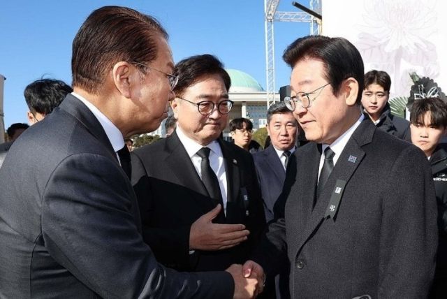 국민의힘 권영세 비상대책위원장(왼쪽)과 더불어민주당 이재명 대표가 31일 서울 여의도 국회에 마련된 제주항공 여객기 사고 희생자 합동분향소에서 조문에 앞서 인사하고 있다. 가운데는 우원식 국회의장. 연합뉴스