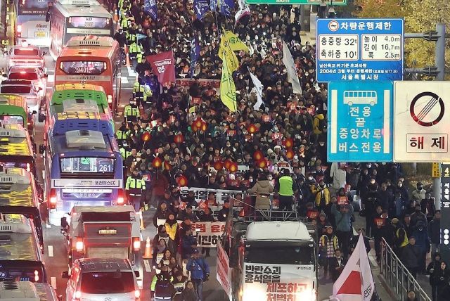 4일 오후 서울 동화면세점 앞에서 열린 ‘내란죄 윤석열 퇴진, 시민촛불’에서 전국민주노동조합총연맹 조합원을 비롯한 참석자들이 용산 대통령실 방향으로 행진하고 있다. 연합뉴스